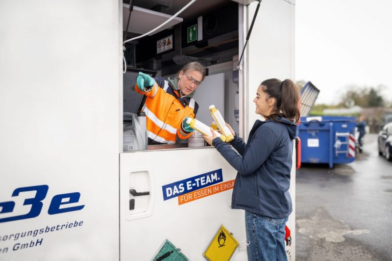 Kundin am Schadstoffmobil gibt Farbtuben ab