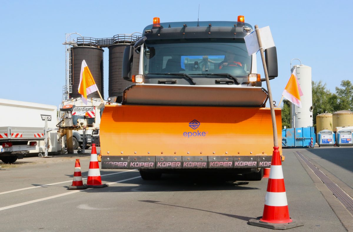 Dreiachser mit Schneepflug fährt durch Pylone, die Engstellen simulieren