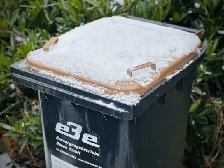 Verschneiter Deckel einer Braunen Tonne für Bioabfall